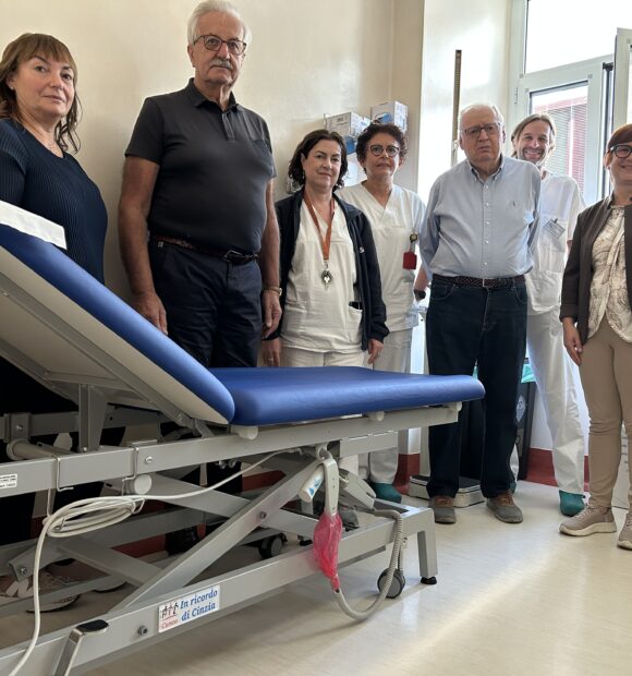 I familiari di Cinzia con uno dei lettini donati, i rappresentanti di Ail, la dottoressa Sara Bringhen, Antonella Ligato e parte dell'équipe del reparto
