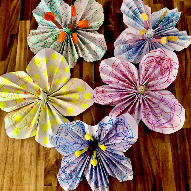five large flowers made out of paper
