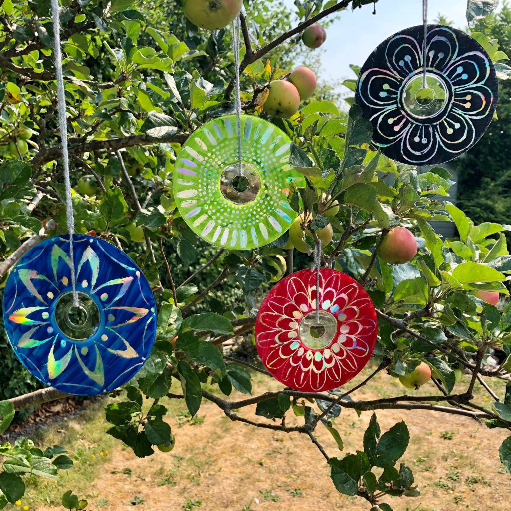 Image of CDs hanging from trees painted like flowers