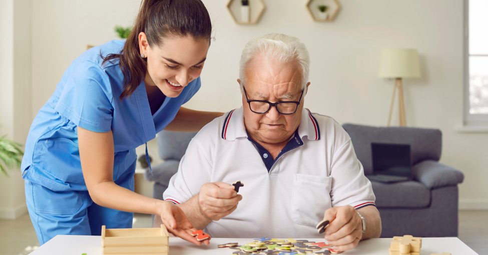 caregiver-helping-elderly-man-puzzle.jpeg