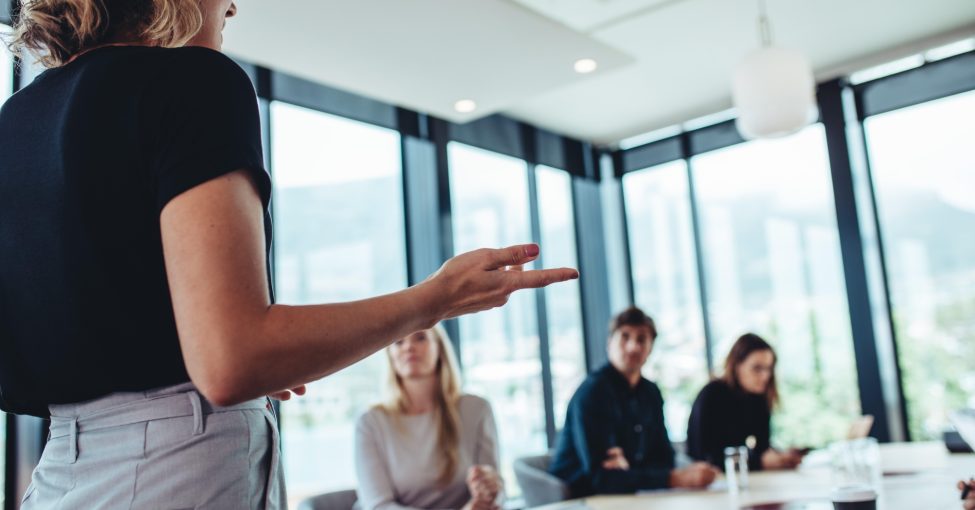 professional with Certificate in Leadership and Management Level 5 standing and leading business meeting