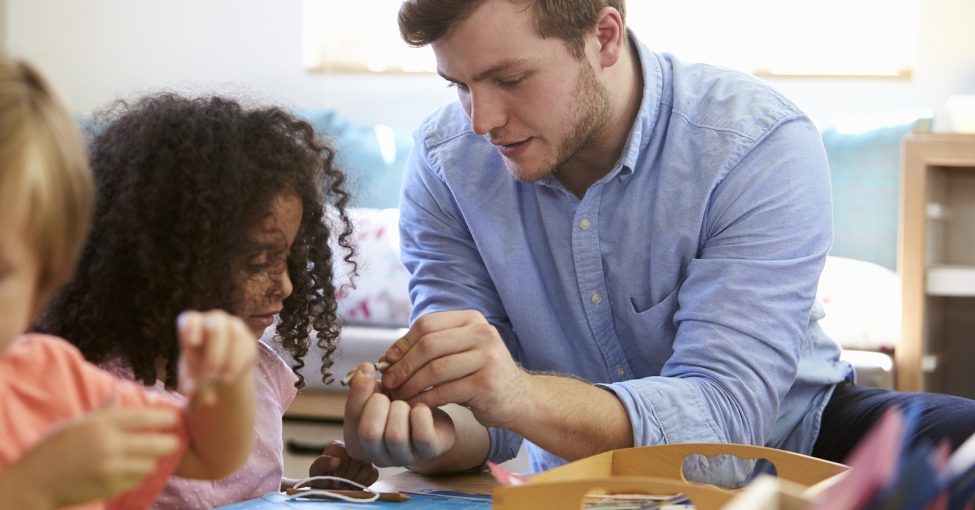 early years educator enabling learning through play with a young child while using toys