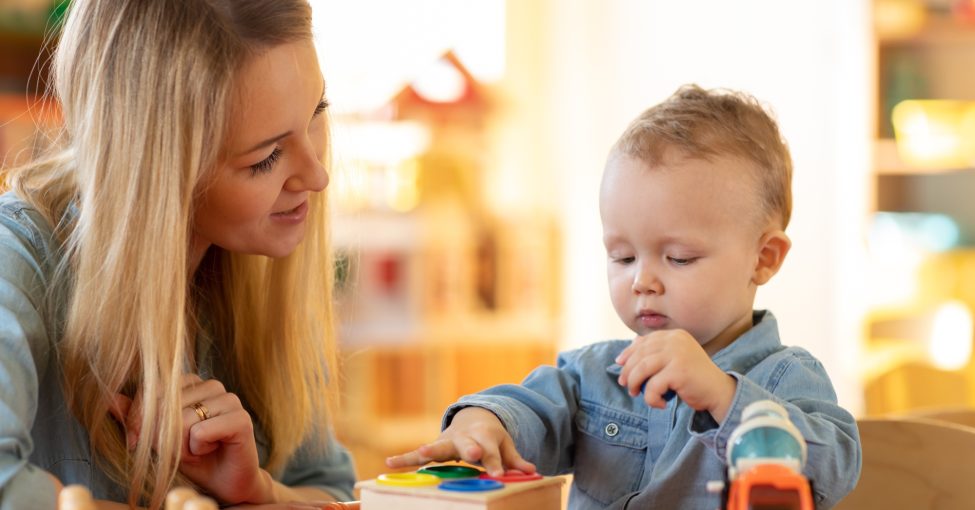 child playing logical toys with educator or apprentice in the classroom in nursery or preschool