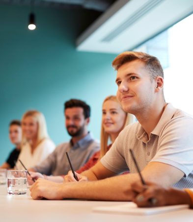 people looking up at person delivering meeting