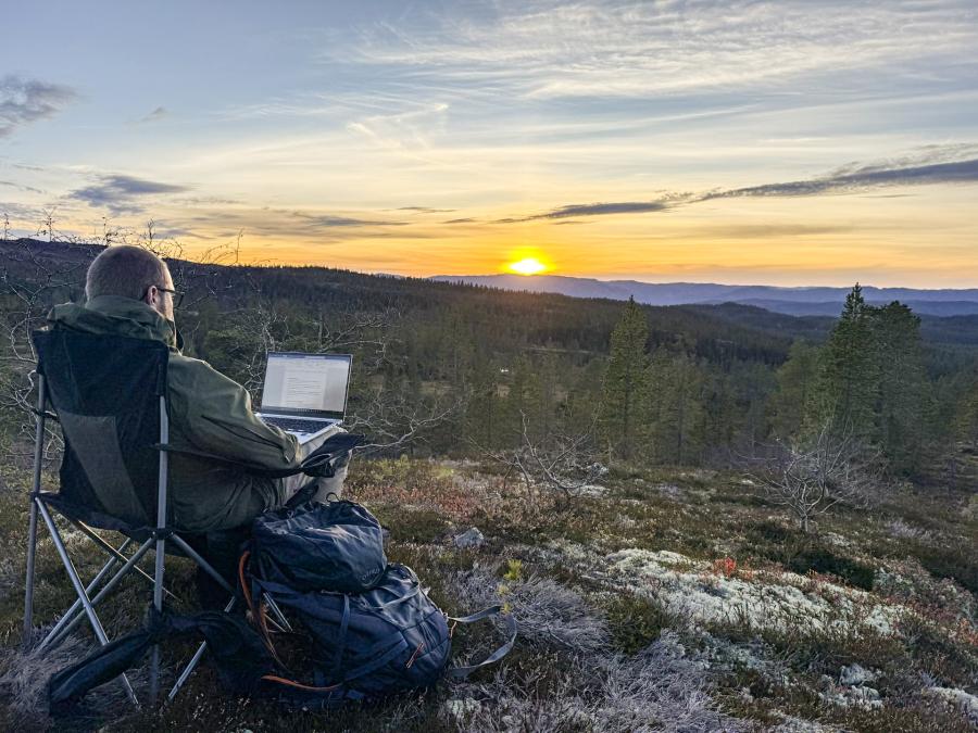Erik sitter i naturen med laptopen