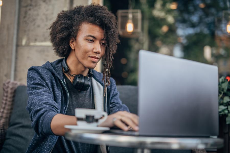 Student som sitter på cafe og jobber ved pc