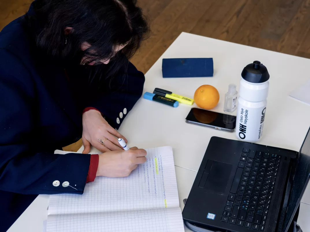 Student foran pc med notatblokk