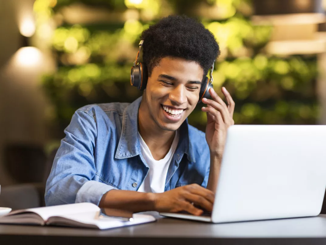 mannlig student med laptop og headset
