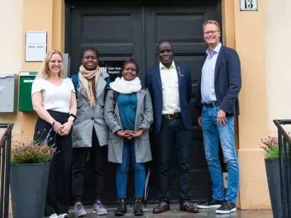fem personer står på trappene foran ONHs campus og smiler mot kamera