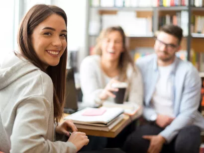 tre studenter smiler til kamera