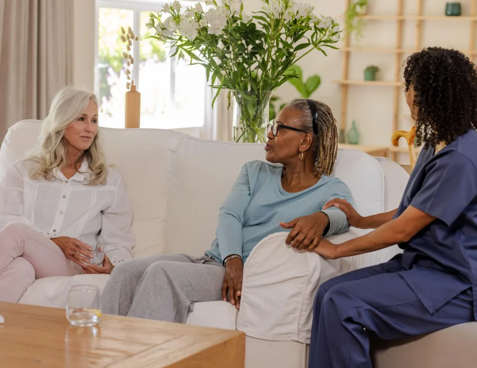 Chatting with caregiver, senior friends having relaxed conversation at home together. Caregiving, companionship, elderly, relaxation, friendship, assistance