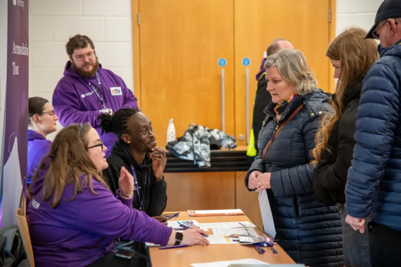 Photo taken during an Open Day: a prospective student and her family booking on to an accommodation tour.