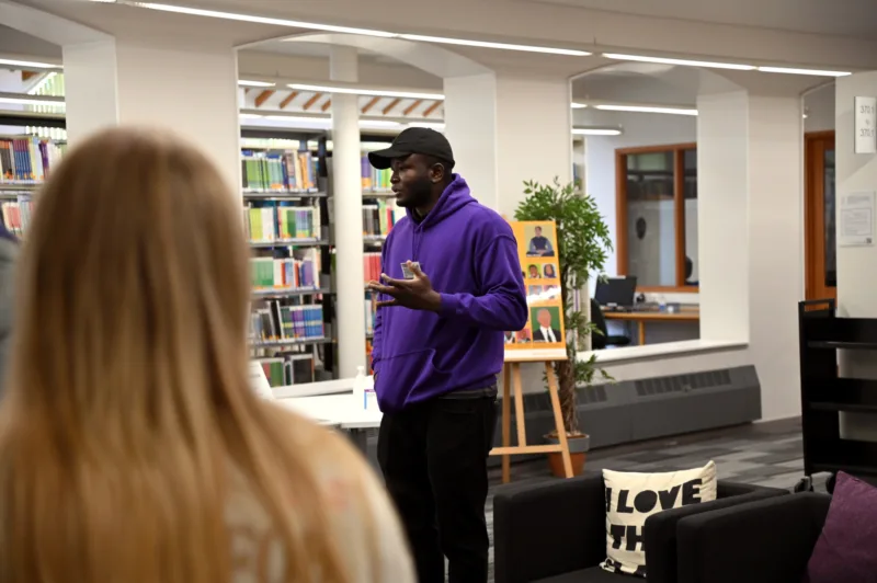 Photo taken during an Open Day: a student ambassador is shown delivering a campus tour in the Library.