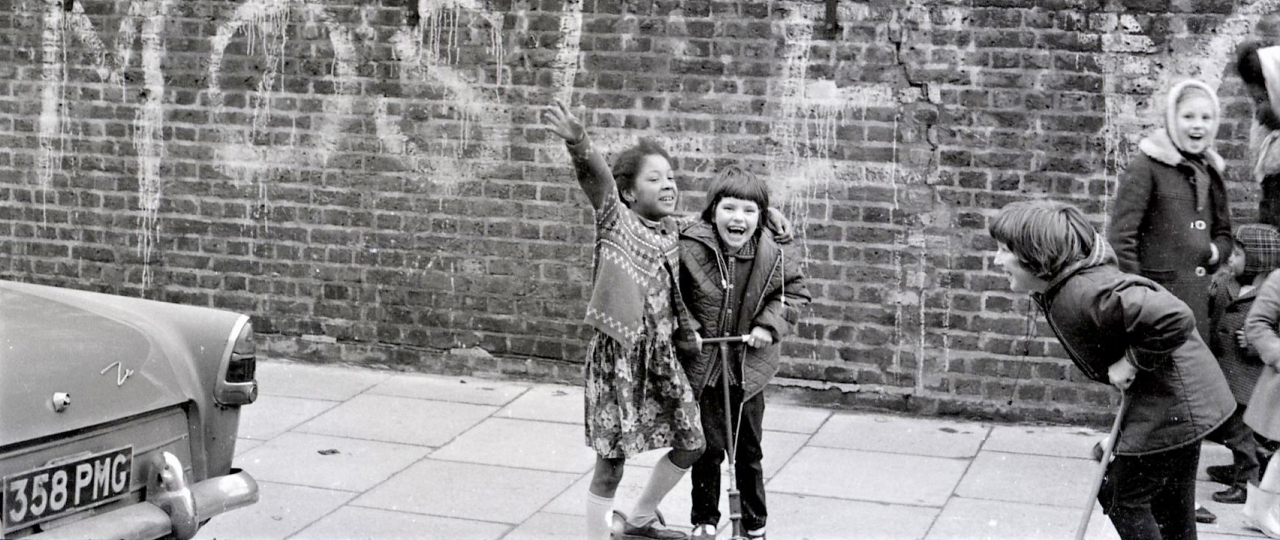 Kids playing by wall covered in graffiti