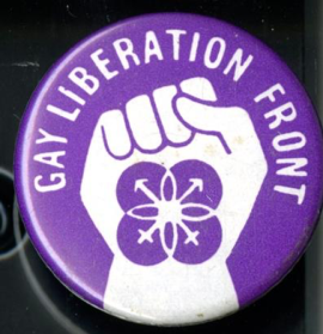 A purple Gay Liberation Front badge with a white fist in the middle and white writing that says: "Gay Liberation Front".