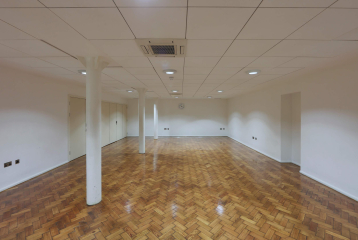Bishopsgate Institute's Goss Room. The floor is laminate, with white walls and white beams to the left of the room.