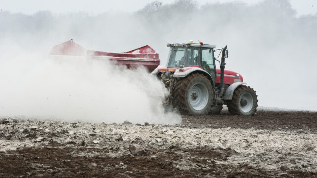 Tractor spreading lime in a field