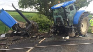 Tractor cut in two after it was hit by a train but the driver survives