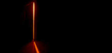 Black room with door ajar with light shining through