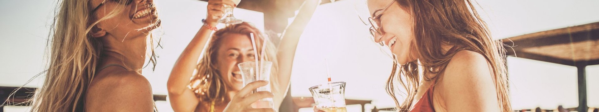 girls on beach drinking cocktails