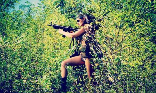 Woman in camo holding an assault rifle. Discover the Driving and Shooting hen party activities from Hen Weekends: