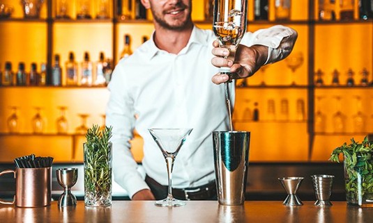 A gentleman mixing a gin cocktail.