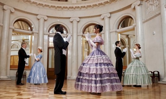 Couples dancing around in period costumes as a part of a hen do activity