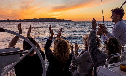 Five people enjoying the sunset on a cruise.