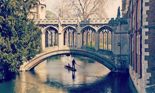Couple punting on a sunny day through the Cambridge canals. Explore Cambridge Hen Party ideas below: