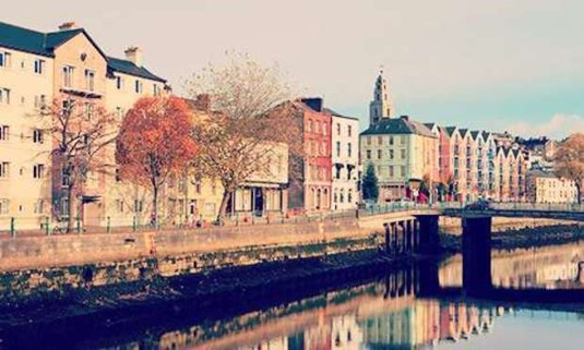 Sunrise picture of the colourful buildings along the River Lee. Explore Cork Hen Party ideas below: