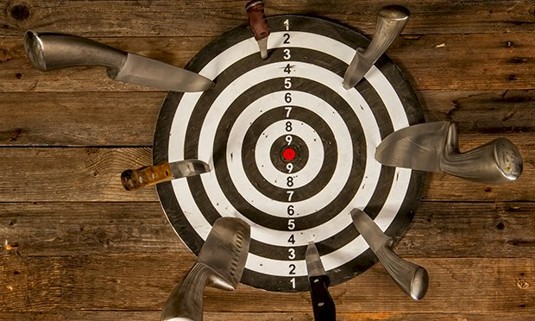 Six knifes in a target board.