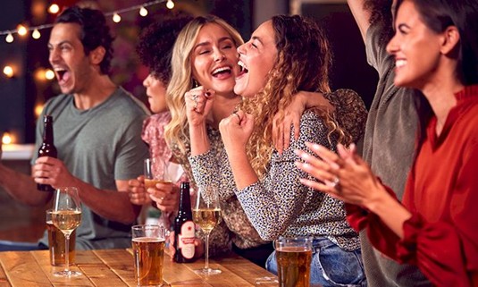 Two girls in a sports bar cheering the teams on