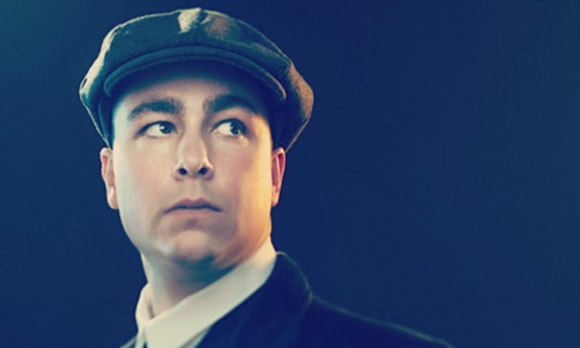 Man in vintage clothes wearing flat-brimmed cap. Click for info about the Liverpool Peaky Blinders tour: