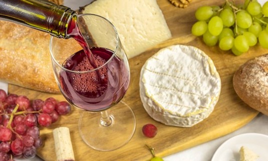 Different cheese and a glass of wine on a platter