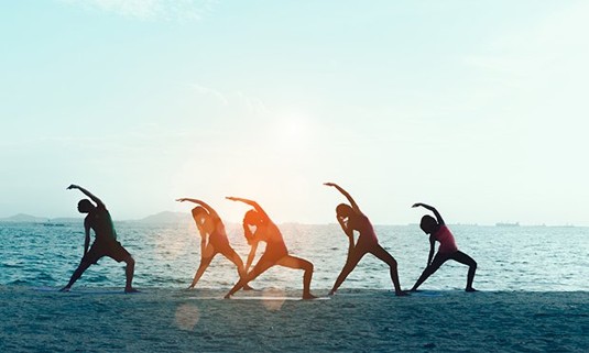 Five ladies enjoying beach yoga.