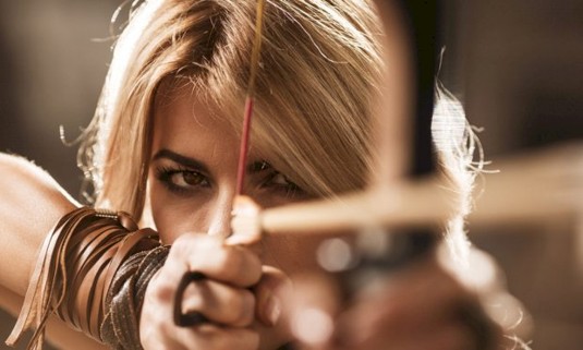 Girl shooting arrow from bow 