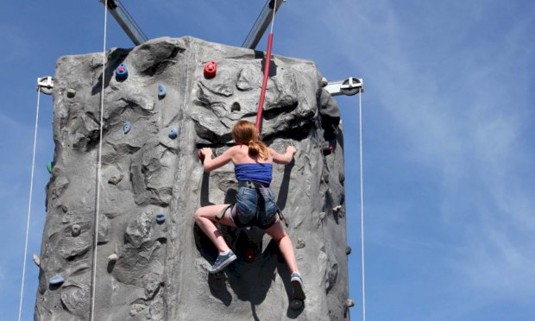 Women on climbing wall half way up 