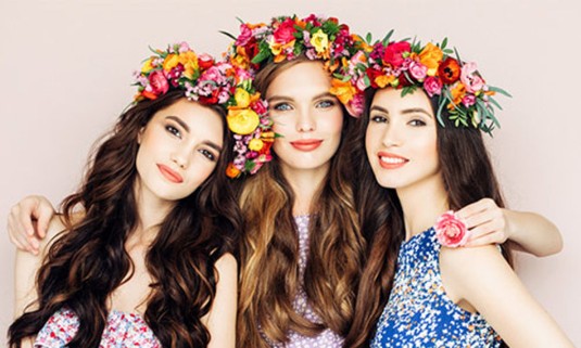 Beautiful flower crowns on the head of three ladies enjoying the hen party activity 