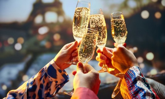 Group of friends clinking glasses Infront of the Eiffel tower