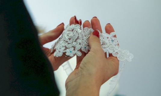 Girl holding piece of lace fabric