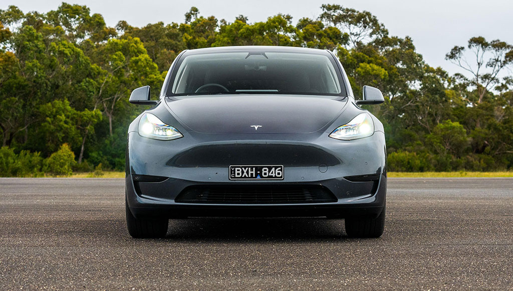 سيارة Tesla Model S أمام خلفية تتضمن أشجار