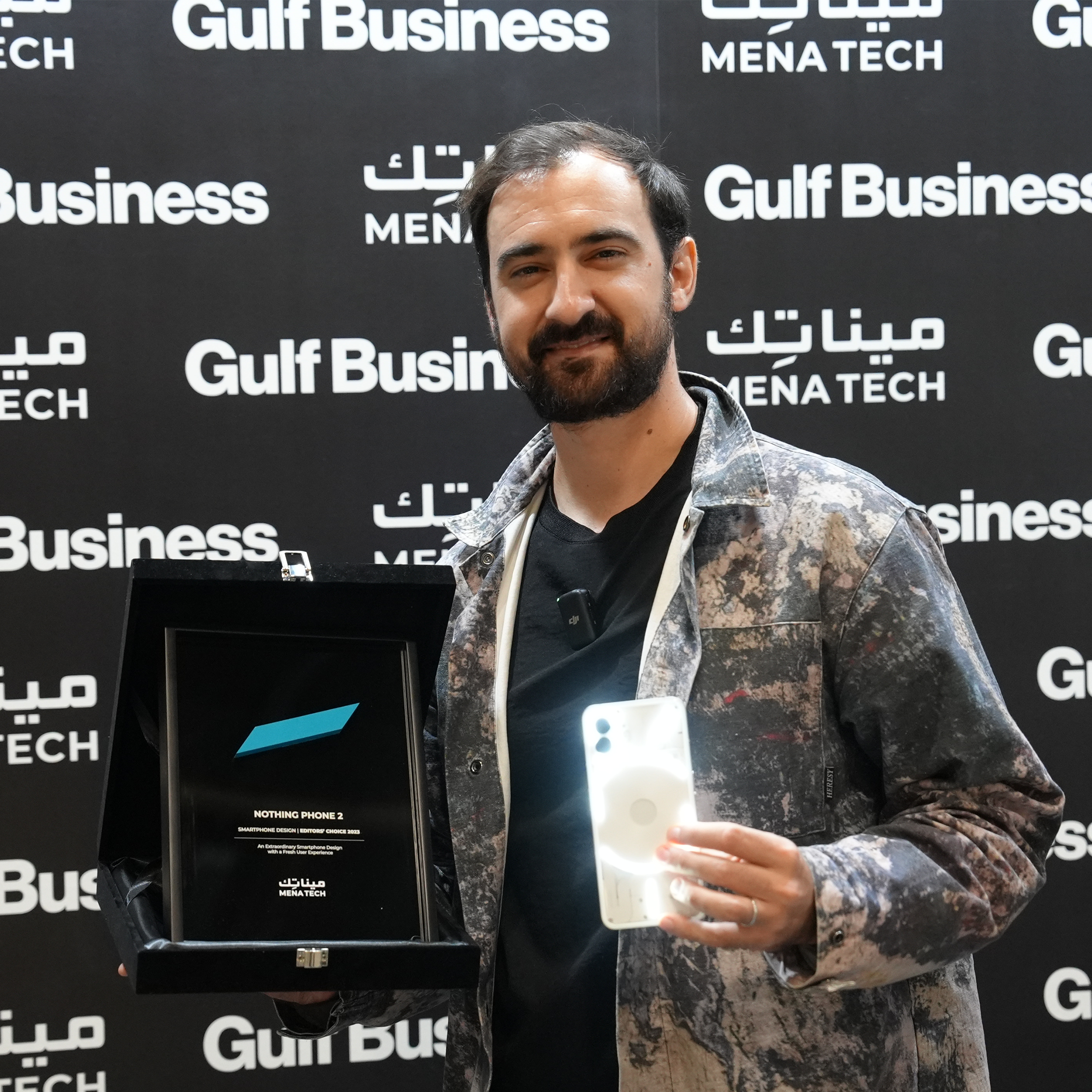 A representative holding the Nothing Phone 2 and the MENA Tech Editors' Choice 2023 award plaque for smartphone design.