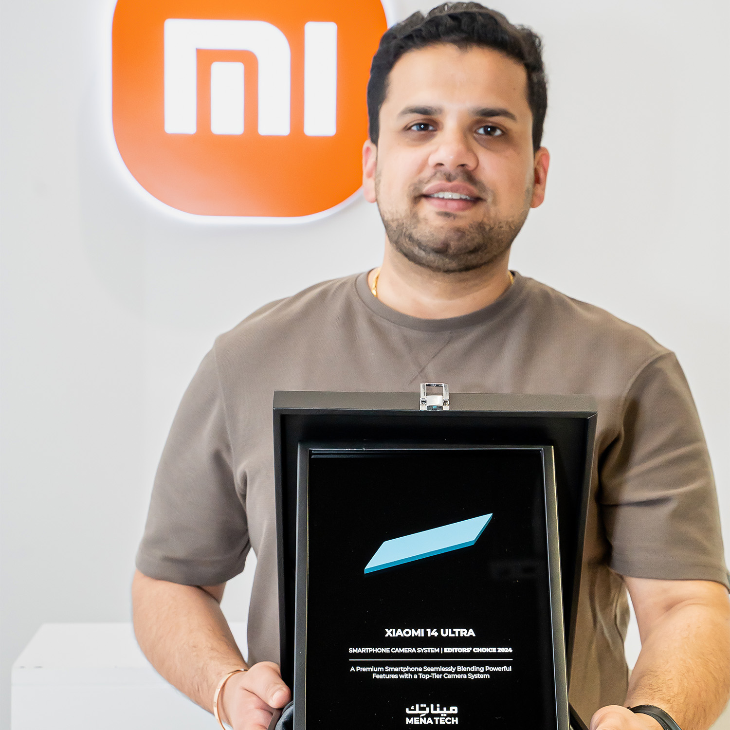 Xiaomi team member showcasing the Xiaomi 14 Ultra Editors' Choice 2024 award from MENA Tech.
