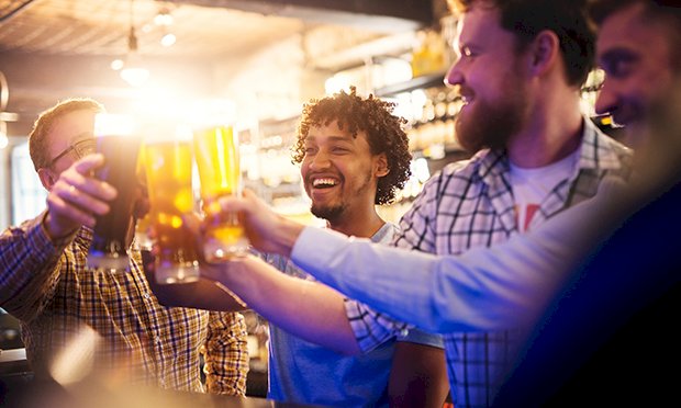 Four men enjoying an open bar in a club.