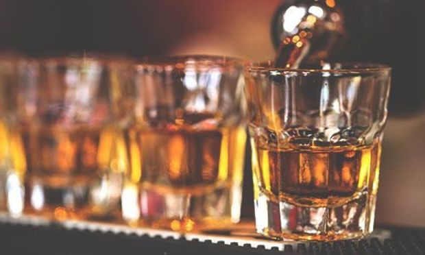 Whisky glasses and whisky being poured into them 