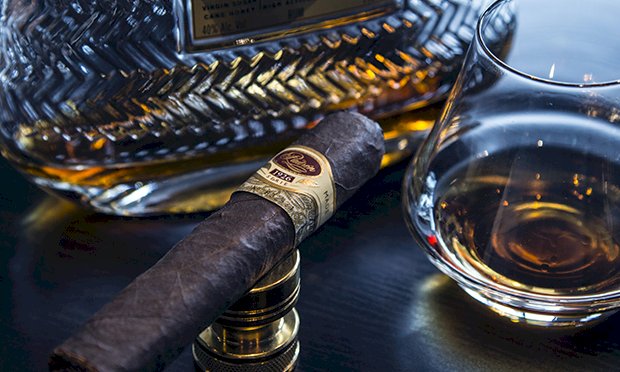 An image of a whisky glass and a cigar.