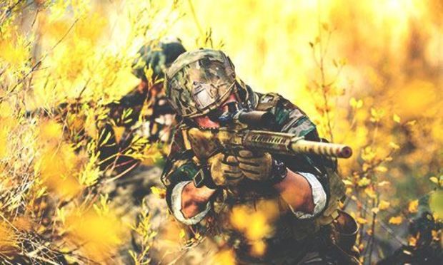 Men in camouflage uniform in field with airsoft guns