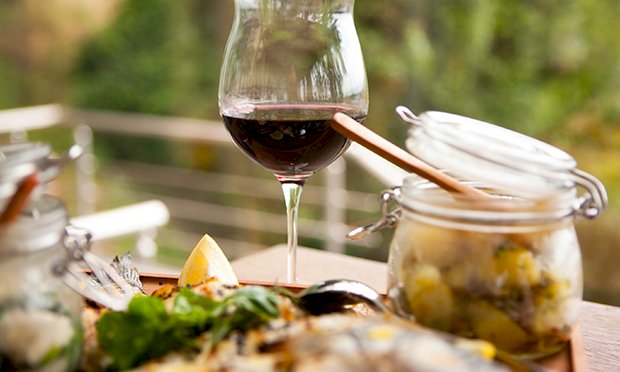 An image of a food board and a glass full of wine.