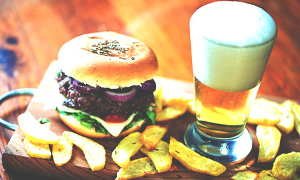 Wooden board with the Glasgow Burger and Beer and a bunch of chips.