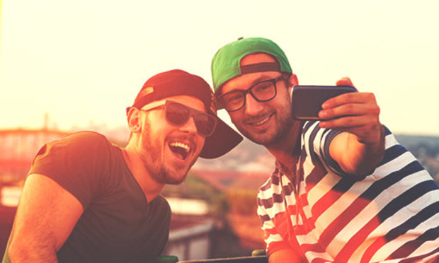 Guy in a green hat and striped shirt takes a selfie with a guy in sunglasses, black hat and black tshirt. Discover the Lincoln Big Man Stag Treasure Hunt experience: